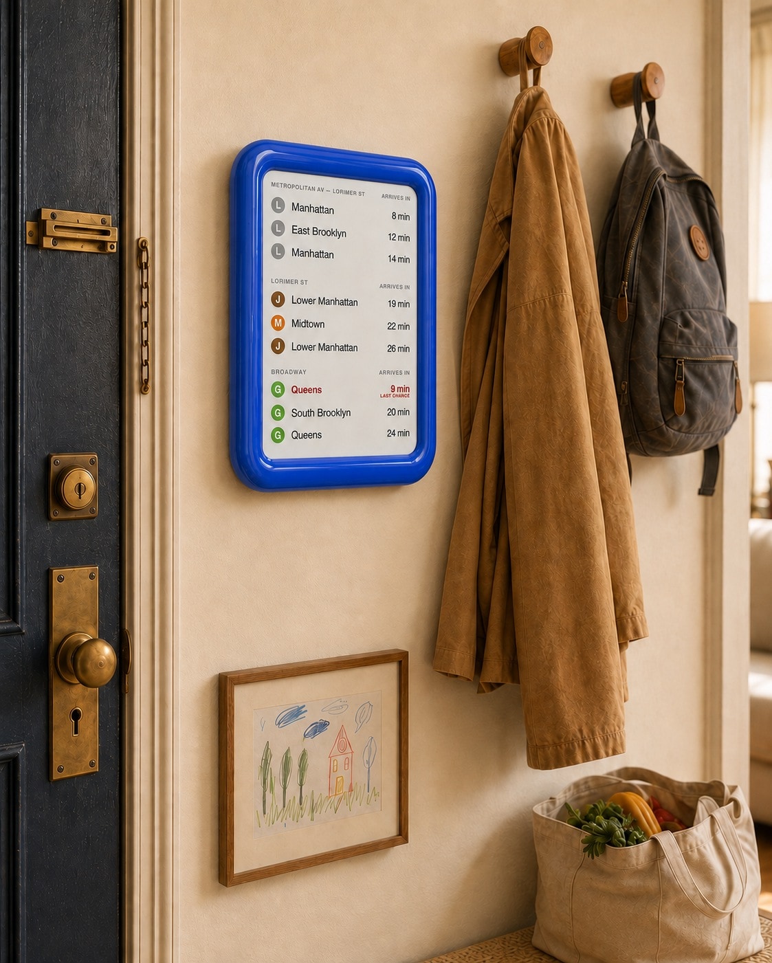 OnMyWay display in blue, mounted in a family entryway beside the coat hooks