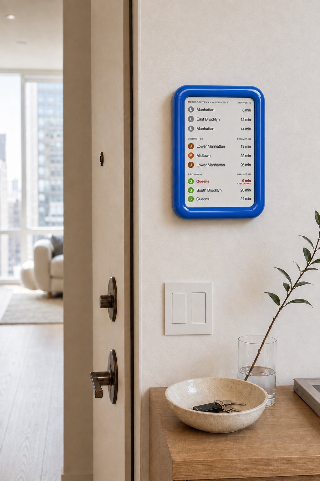OnMyWay display in blue, mounted by the door of a modern apartment